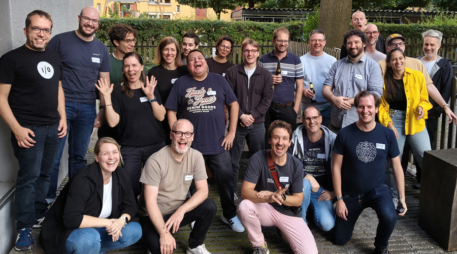 A wide group photo of software engineers, open-source developers, and tech organizers posing and smiling together outside the venue during the Drupal AI Hackathon recap.