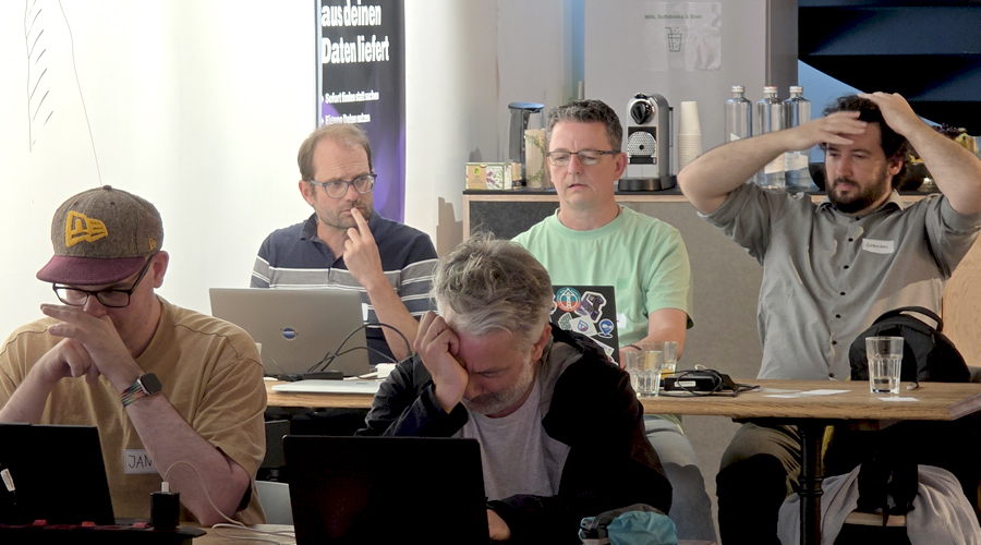 A group of tech developers looking intensely focused, deep in thought, and debugging complex problems on their laptops during an intensive open-source AI development sprint.